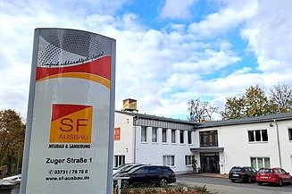 Unternehmensstandort der SF‑Ausbau GmbH in Freiberg mit Firmenstele und Bürogebäude – Karrierechancen bei einem regionalen Bauunternehmen in Sachsen.