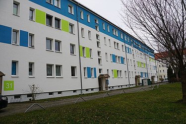 Modernisierte Wohnanlage mit farblich gestalteter Fassade in Blau und Grün – professionelle Fassadensanierung und Malerarbeiten durch SF‑Ausbau in Freiberg und Sachsen.