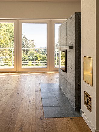Moderner Wohnbereich mit hochwertigem Parkettboden, Kaminofen und bodentiefen Fenstern – präzise Bodenbelagsarbeiten und Innenausbau von SF‑Ausbau im Einfamilienhaus in Freiberg.