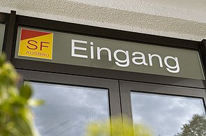 Eingang zum Büro von SF‑Ausbau in Freiberg mit Firmenlogo – kompetenter Ansprechpartner für Innenausbau, Sanierung und Bauprojekte in Mittelsachsen.