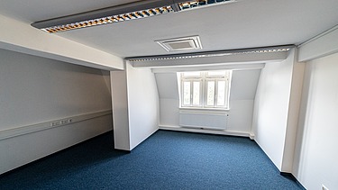 Modernisierter Büroraum im Verwaltungsgebäude Hansastraße 11 in Dresden mit Teppichboden, Dachschräge, integrierter Beleuchtung und hochwertigem Innenausbau – schlüsselfertige Sanierung durch SF‑Ausbau.