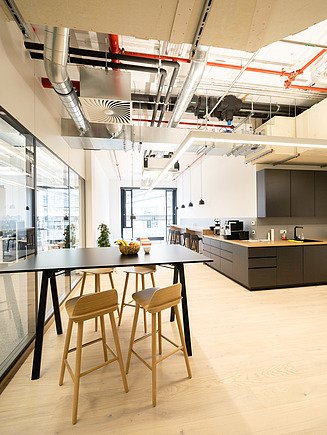 Moderne Büroküche mit sichtbarer Haustechnik, Lüftungsanlage und hochwertigen Innenausbauelementen am Postplatz Dresden – professionelle Heizung-, Lüftung-, Sanitär- und Elektroarbeiten von SF‑Ausbau.