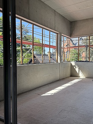 Trockenbau im Obergeschoss des Karl-May-Museums in Radebeul mit großflächigen Fensteröffnungen, Sichtbetonwänden und vorbereiteten Metallständerprofilen – professioneller Innenausbau durch SF‑Ausbau.
