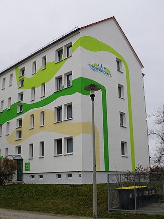 Modernisierte Wohnanlage mit kreativ gestalteter Fassade in Grün- und Beigetönen – hochwertige Malerarbeiten, Fassadengestaltung und Wohnraumsanierung durch SF‑Ausbau in Sachsen.