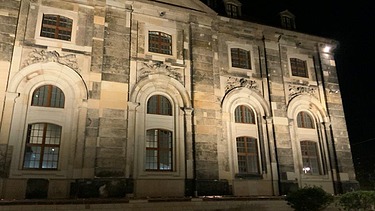 Historische Sandsteinfassade eines denkmalgeschützten Gebäudes in Dresden bei Nachtbeleuchtung – hochwertige Elektroarbeiten, Fassadeninszenierung und Gebäudetechnik von SF‑Ausbau.