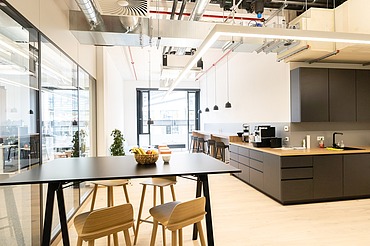 Moderne Aufenthalts- und Küchenzone im Bürogebäude am Postplatz Dresden mit sichtbarer Lüftungstechnik, offener Haustechnik und hochwertigem Innenausbau – Heizung-, Lüftung-, Sanitär- und Elektroarbeiten von SF‑Ausbau.