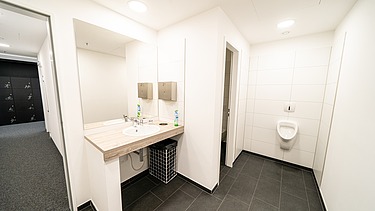 Moderner Sanitärbereich mit Waschbecken, Spiegeln, Fliesenboden und hochwertiger Sanitärinstallation im Bürogebäude am Postplatz Dresden – professioneller Innenausbau und Gebäudetechnik von SF‑Ausbau.