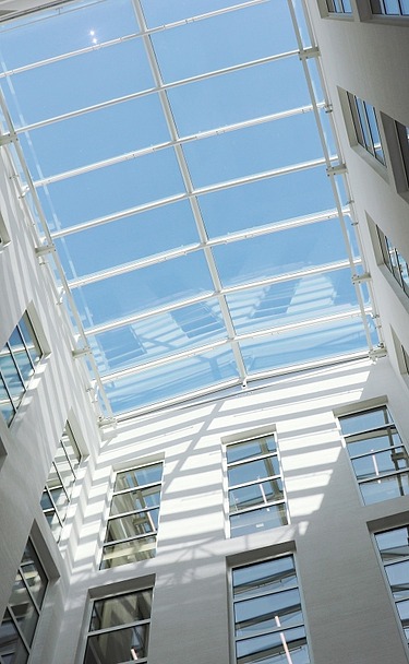 Lichtdurchflutetes Glasdach-Atrium der TU Bergakademie Freiberg mit moderner Architektur und großzügigen Fensterflächen – hochwertiger Innenausbau und Trockenbau von SF‑Ausbau.