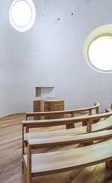 Individuell ausgebaute Kapelle mit geschwungenen Sitzreihen aus Holz, Oberlicht und hochwertigem Trockenbau im Probst-Beier-Haus Dresden – präziser Innenausbau von SF‑Ausbau.
