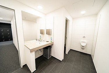 Moderner Sanitärbereich mit Waschbecken, Spiegeln, Fliesenboden und barrierefreiem Ausbau im Bürogebäude am Postplatz Dresden – professionelle Sanitärinstallation und Innenausbau von SF‑Ausbau.