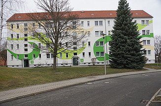 Modernisierte Wohnanlage mit farblich gestalteter Fassade – professionelle Malerarbeiten, Fassadensanierung und Wohnungsmodernisierung durch SF‑Ausbau in Freiberg und Mittelsachsen.