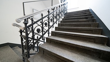 Saniertes Treppenhaus mit Natursteinstufen und denkmalgerechtem Metallgeländer im Verwaltungsgebäude an der Hansastraße in Dresden – hochwertige Sanierung und schlüsselfertiger Innenausbau durch SF‑Ausbau.