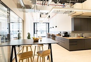 Moderne Aufenthalts- und Küchenzone im Bürogebäude am Postplatz Dresden mit sichtbarer Lüftungstechnik, offener Haustechnik und hochwertigem Innenausbau – Heizung-, Lüftung-, Sanitär- und Elektroarbeiten von SF‑Ausbau.