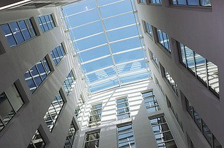 Modernes Büro- und Verwaltungsgebäude mit lichtdurchflutetem Glasdach-Atrium an der TU Bergakademie Freiberg – hochwertiger Innenausbau und schlüsselfertige Bauleistungen von SF‑Ausbau.